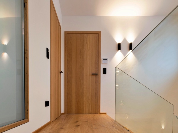 Innentür aus Holz in hellem Vorraum mit Glasgeländer